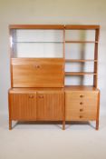 A 1970s modular teak wall unit, one side with glazed display cabinet over fall front cocktail