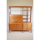 A 1970s modular teak wall unit, one side with glazed display cabinet over fall front cocktail