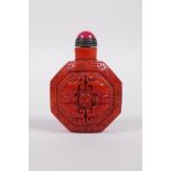 A coral coloured Peking glass snuff bottle of octagonal form with moulded bat and auspicious