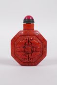 A coral coloured Peking glass snuff bottle of octagonal form with moulded bat and auspicious