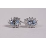 A pair of 18ct white gold, aquamarine and diamond cluster earrings, approximately 1.3cts
