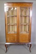 An Edwardian inlaid mahogany display cabinet with astragal glazed doors, raised on cabriole
