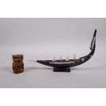 An Indian bone and horn carving of a boat, and a bone carving of a monkey, largest 9" long