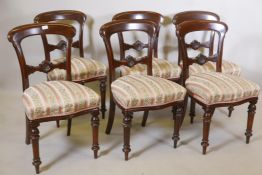 A set of six Victorian mahogany shaped back dining chairs, with carved and shaped rails, raised on
