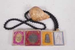 A collection of four Thai amulets in plastic display cases, three of Buddha and one of the King, and