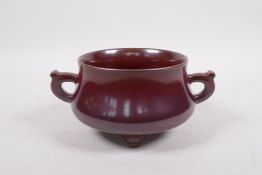A Chinese copper glazed porcelain two handled censer, raised on tripod feet, seal mark to base, 5"