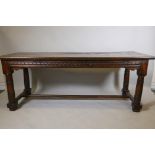 An antique oak refectory table, with plank top and carved frieze raised on gun barrel turned