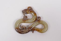 A Chinese antique mottled celadon jade pendant carved in the form of a dragon, 3½" x 3"