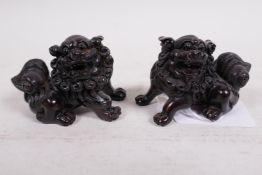 A pair of carved wooden netsuke carved as kylin, signed, 2" long