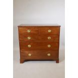 An early C19th mahogany chest of two plus three drawers, with brass oval plate handles, raised on