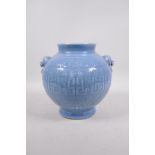 A light blue glazed porcelain vase with two lion mask handles and archaic style decoration, seal