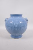 A light blue glazed porcelain vase with two lion mask handles and archaic style decoration, seal