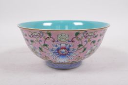A Chinese polychrome porcelain rice bowl with enamelled lotus flower decoration on a pink ground,