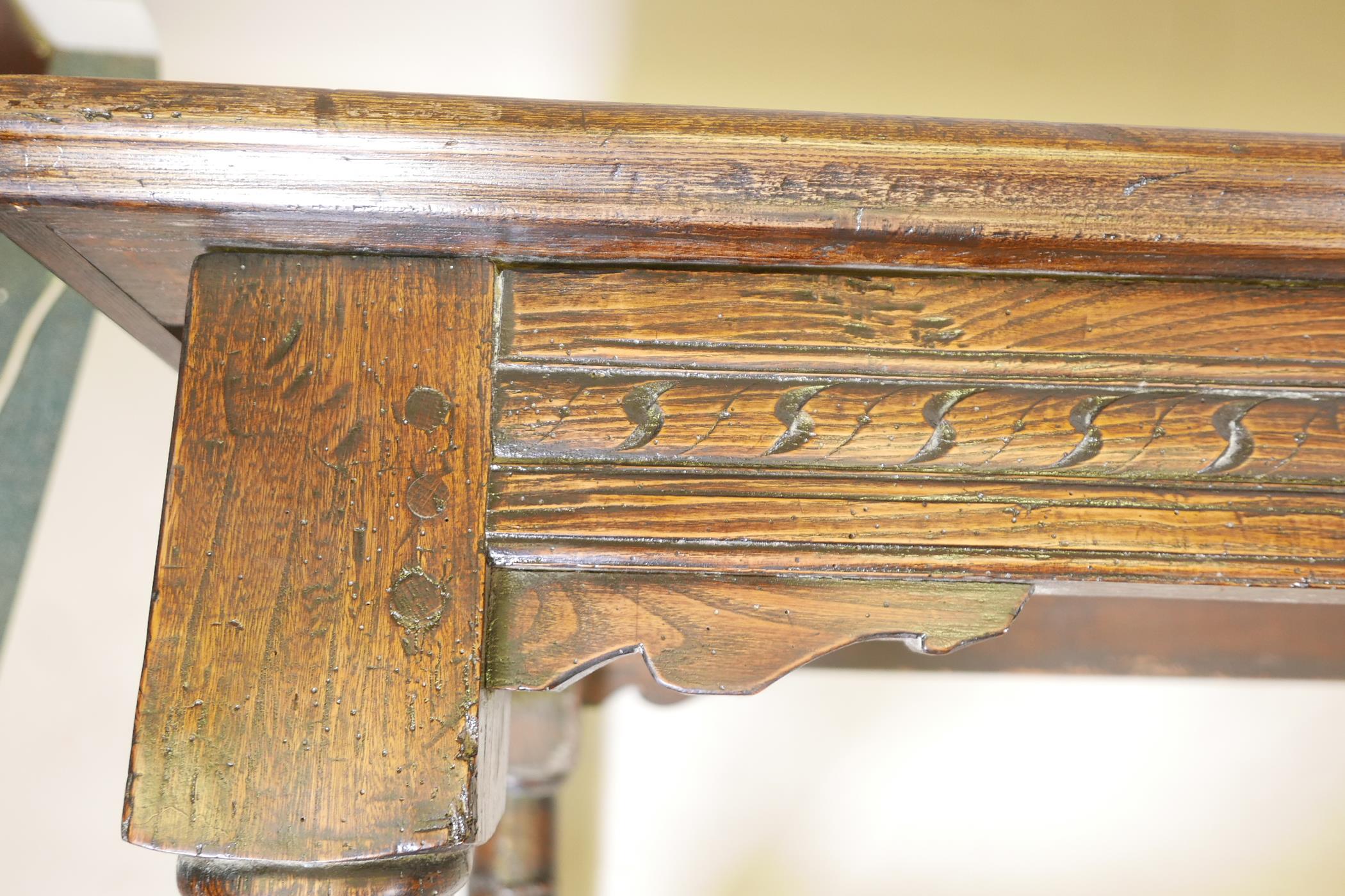 An antique oak refectory table, with plank top and carved frieze raised on gun barrel turned - Image 9 of 9