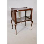 A mahogany two tier side table with galleried top and drop down sides inset with mirrors, raised