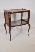 A mahogany two tier side table with galleried top and drop down sides inset with mirrors, raised