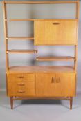 A mid C20th G-Plan teak room divider, the upper section fitted with fall front drink cabinet,