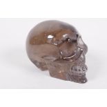 A carved rock crystal skull, 4" long