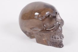 A carved rock crystal skull, 4" long