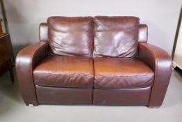 A brown leather two seater club sofa, 63" wide, 35" high