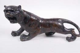 A Oriental bronze figure of a roaring tiger, 12½" long