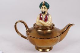 A Wade Pottery 'The Genie' teapot with gold resist glazed body and painted figurine