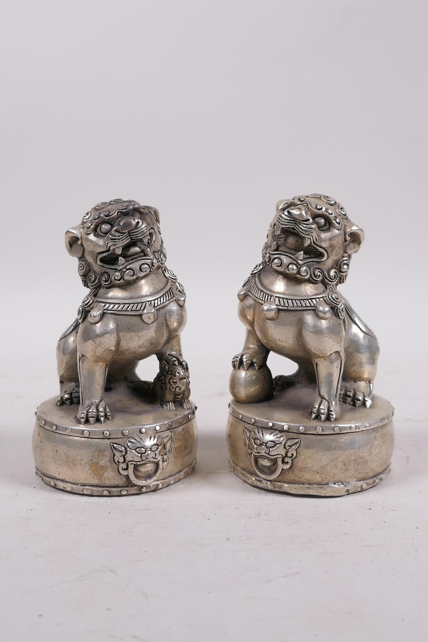 A pair of Chinese filled white metal fo dogs, 4 character mark to base, 4½" high