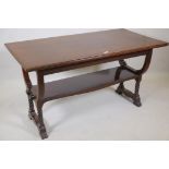 A C19th mahogany two tier Arts and Crafts centre table, raised on shaped end supports with pegged