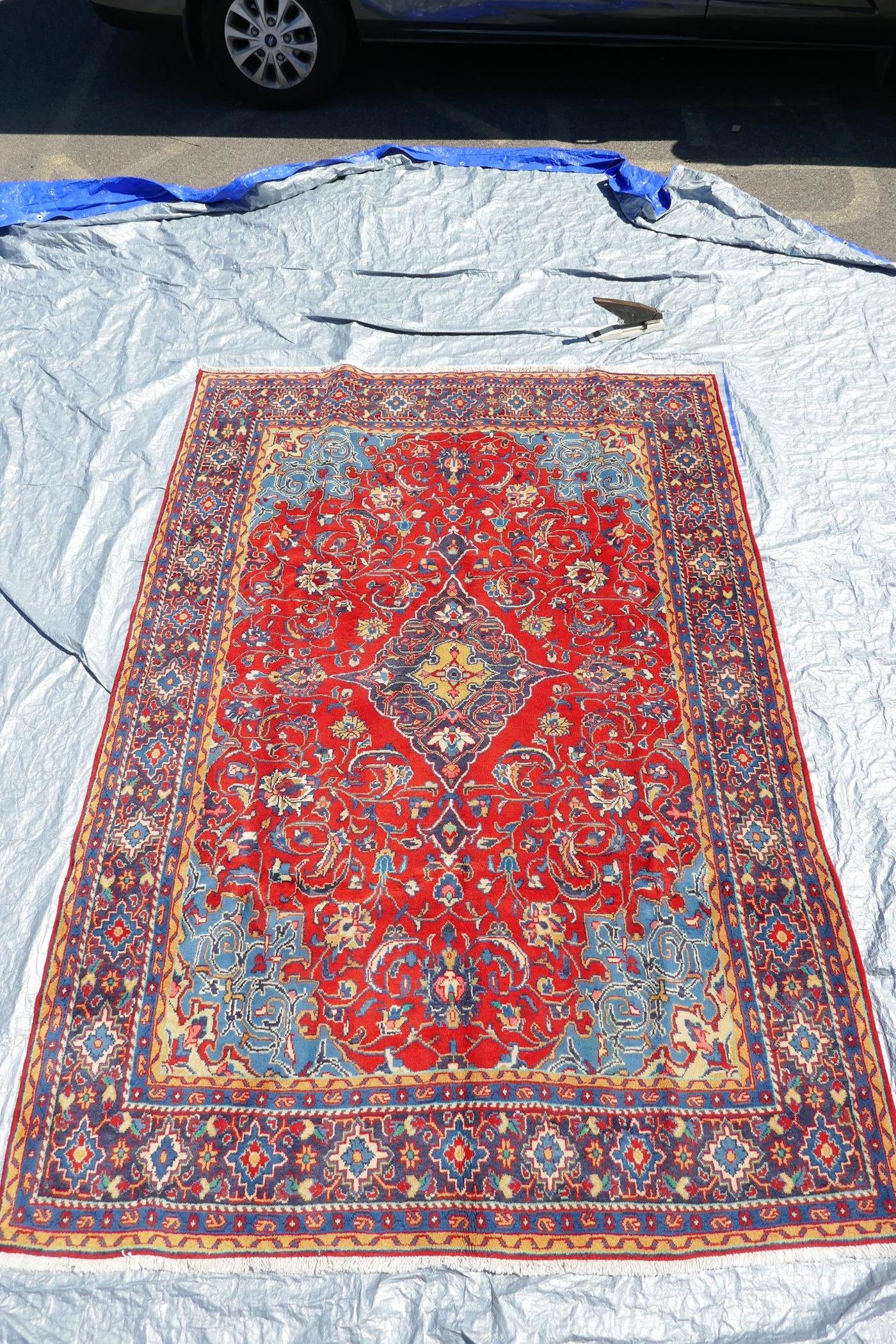 A full pile fine woven Sarouk carpet with a floral medallion design on a red field, 112" x 78" - Image 2 of 5