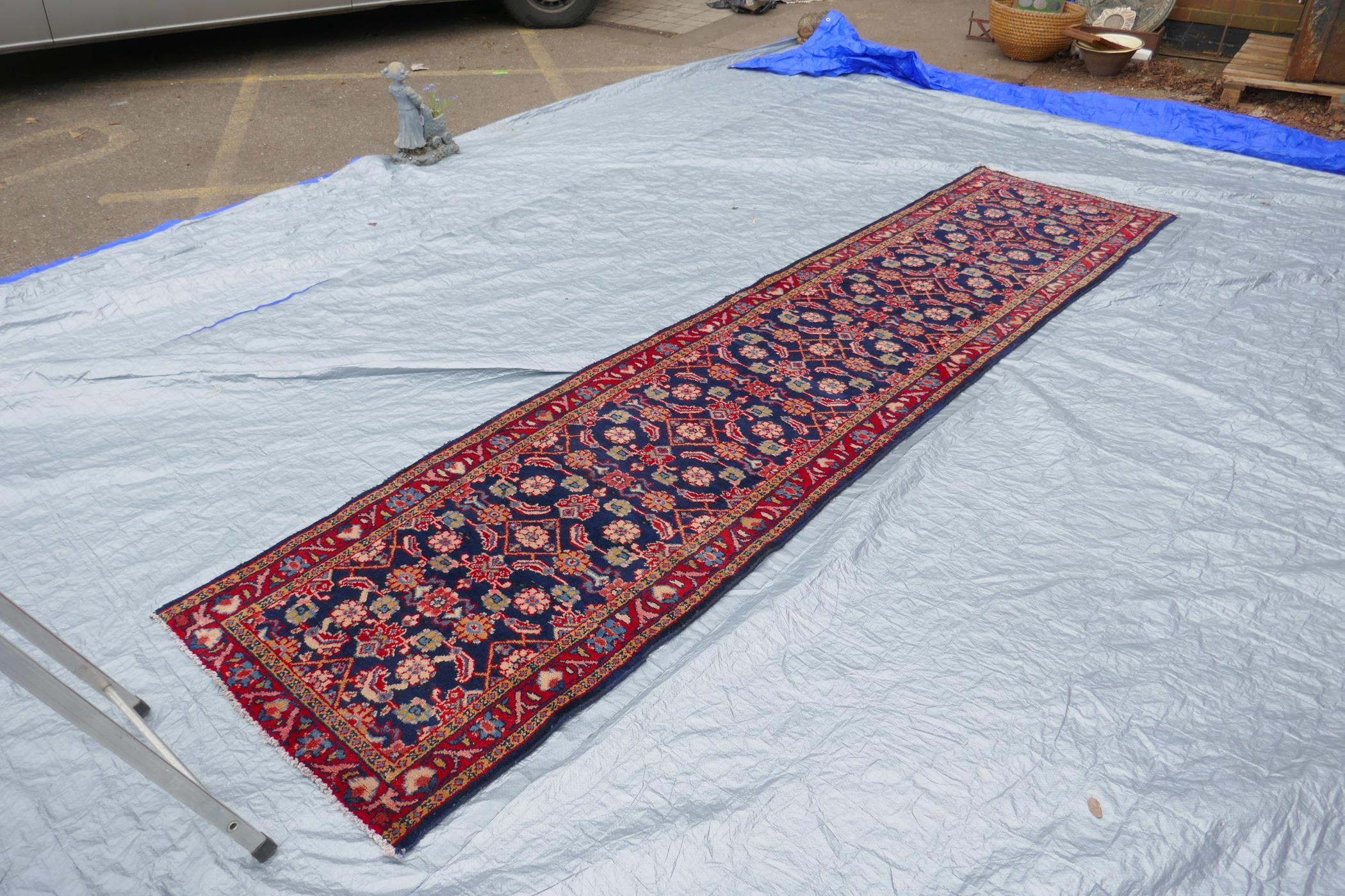 A blue ground Persian Sarouk runner with all over design and red borders, 33" x 140" - Image 4 of 8
