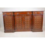 A Regency mahogany breakfront sideboard, the four doors fitted with brass grills, raised on a plinth