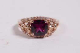 A 14ct rose gold ring set with a garnet and diamonds, approximate size 'N'