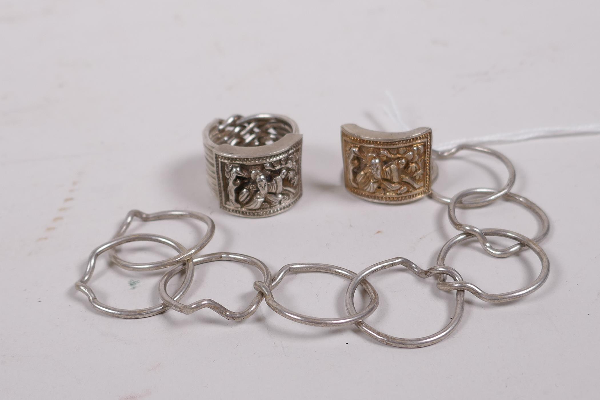 Two Chinese white metal nine link rings, with repousse decoration of a sage - Image 3 of 4