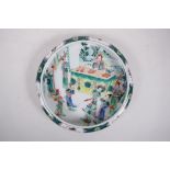 A Chinese famille verte porcelain dish with a rolled rim, decorated with a court scene, Kangxi 6