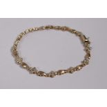 A 10ct yellow gold and diamond set bracelet, 7" long