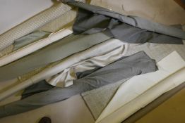 Eight end of rolls of fabric, mostly neutral colours