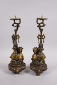 A pair of brass pricket candlesticks in the form of rams, raised on a stylised lotus base with