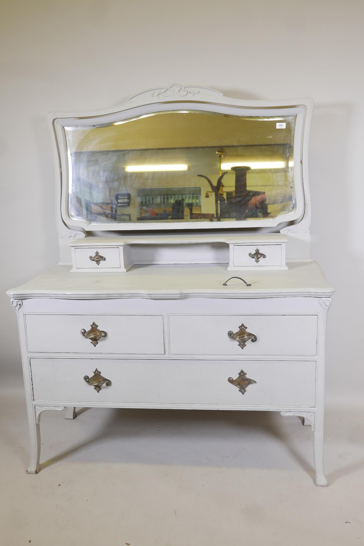 An Edwardian painted dressing table, with carved details, the mirrored top section with two drawers,