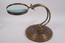 A brass framed desk top magnifying glass on a weighted base, lens, 5" diameter