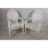 A pair of carved and painted French style open arm chairs