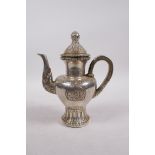 A Tibetan white metal teapot decorated with Buddhist emblems, double vajra mark to base, 8" high