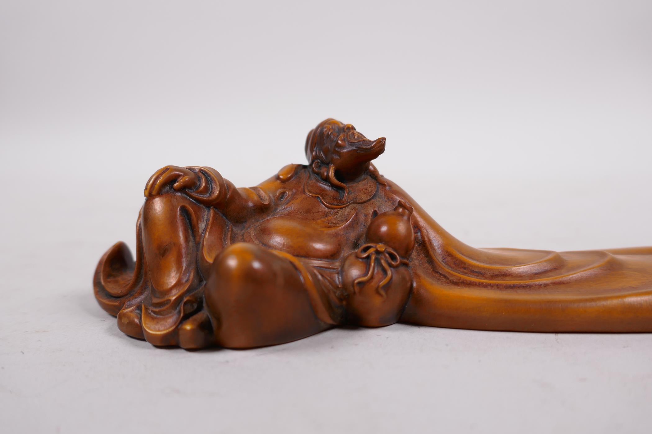 A Chinese carved boxwood incense stick holder in the form of a reclining sage, 7½" long - Image 2 of 3