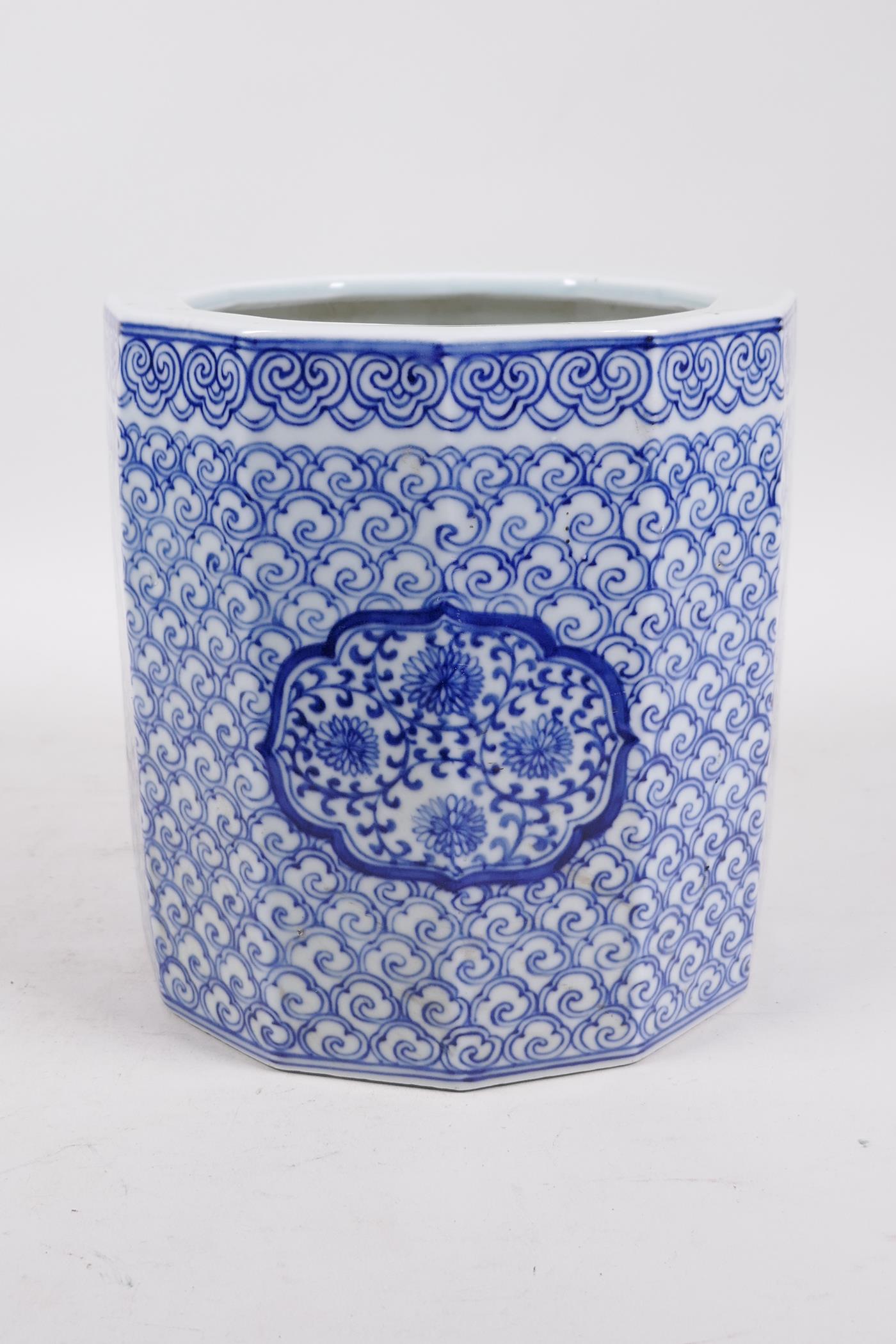 A Chinese Republic blue and white porcelain brush pot with decorative floral panels, 7" high x 7"