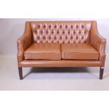 A button back leather two seater settee, with brass studded detail, raised on square tapering