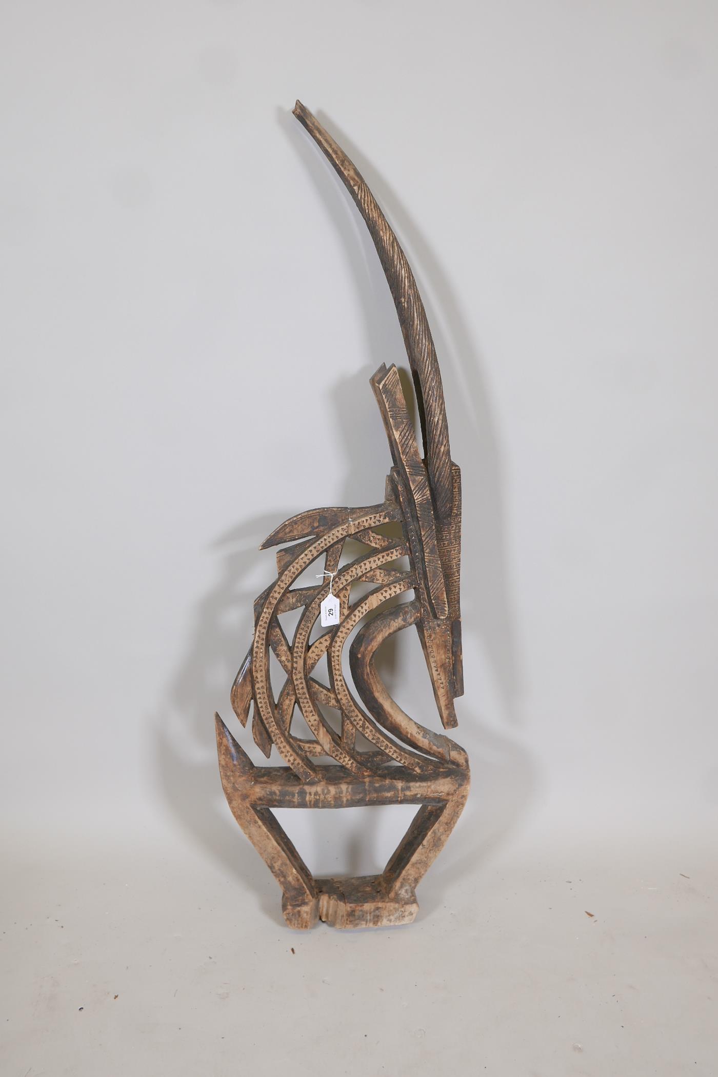 An African carved wood stylised figure of a antelope, A/F, 44" high
