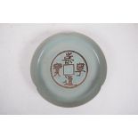 A Song style celadon glazed porcelain dish with lobed rim and chased 'cash' coin decoration,