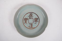 A Song style celadon glazed porcelain dish with lobed rim and chased 'cash' coin decoration,