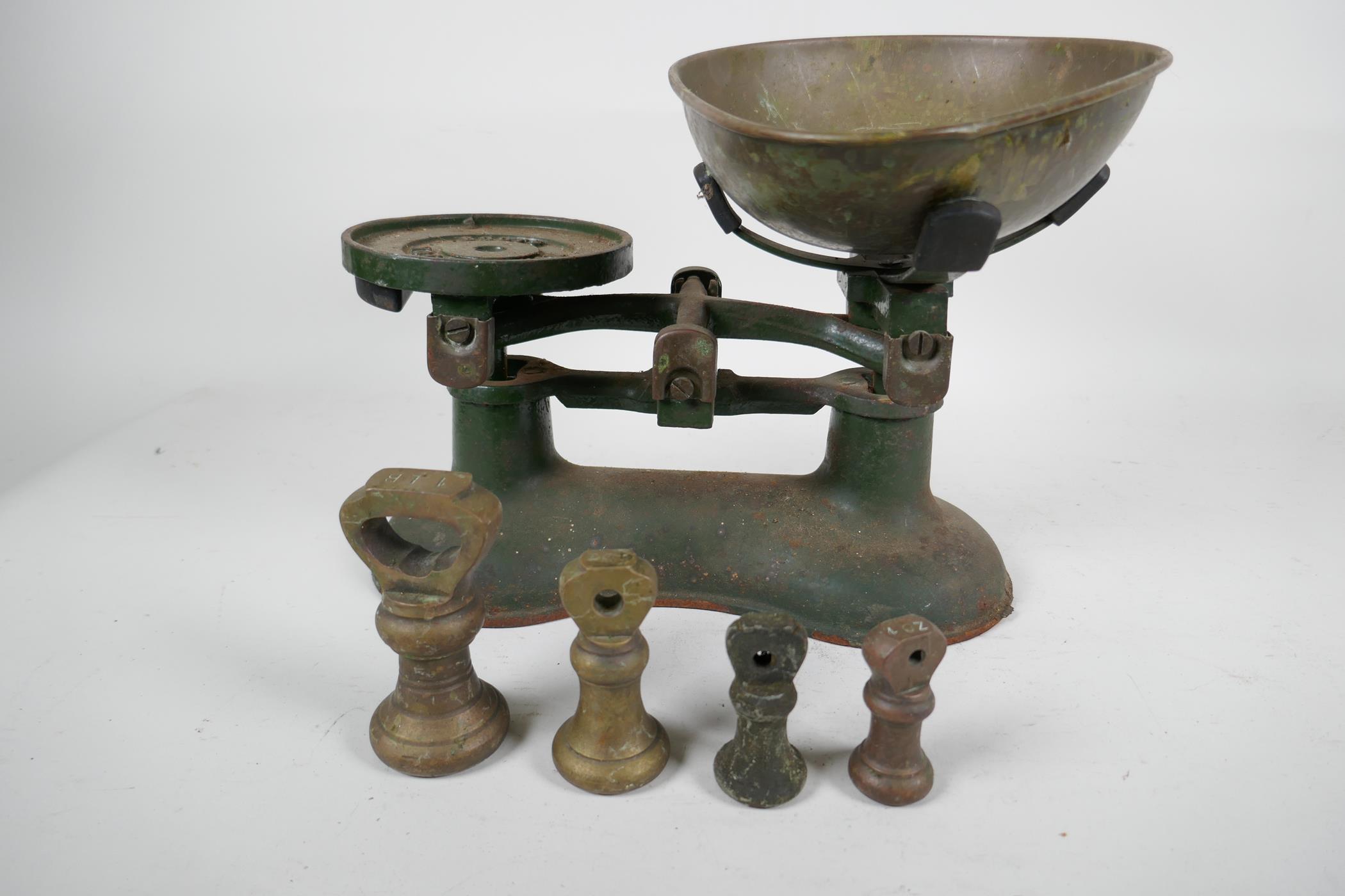A set of Boots iron kitchen scales with brass pan and four brass bell weights, and a barometer