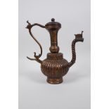 An Islamic gilt bronze ewer with a ribbed body and spiral shaped spout, 9" high
