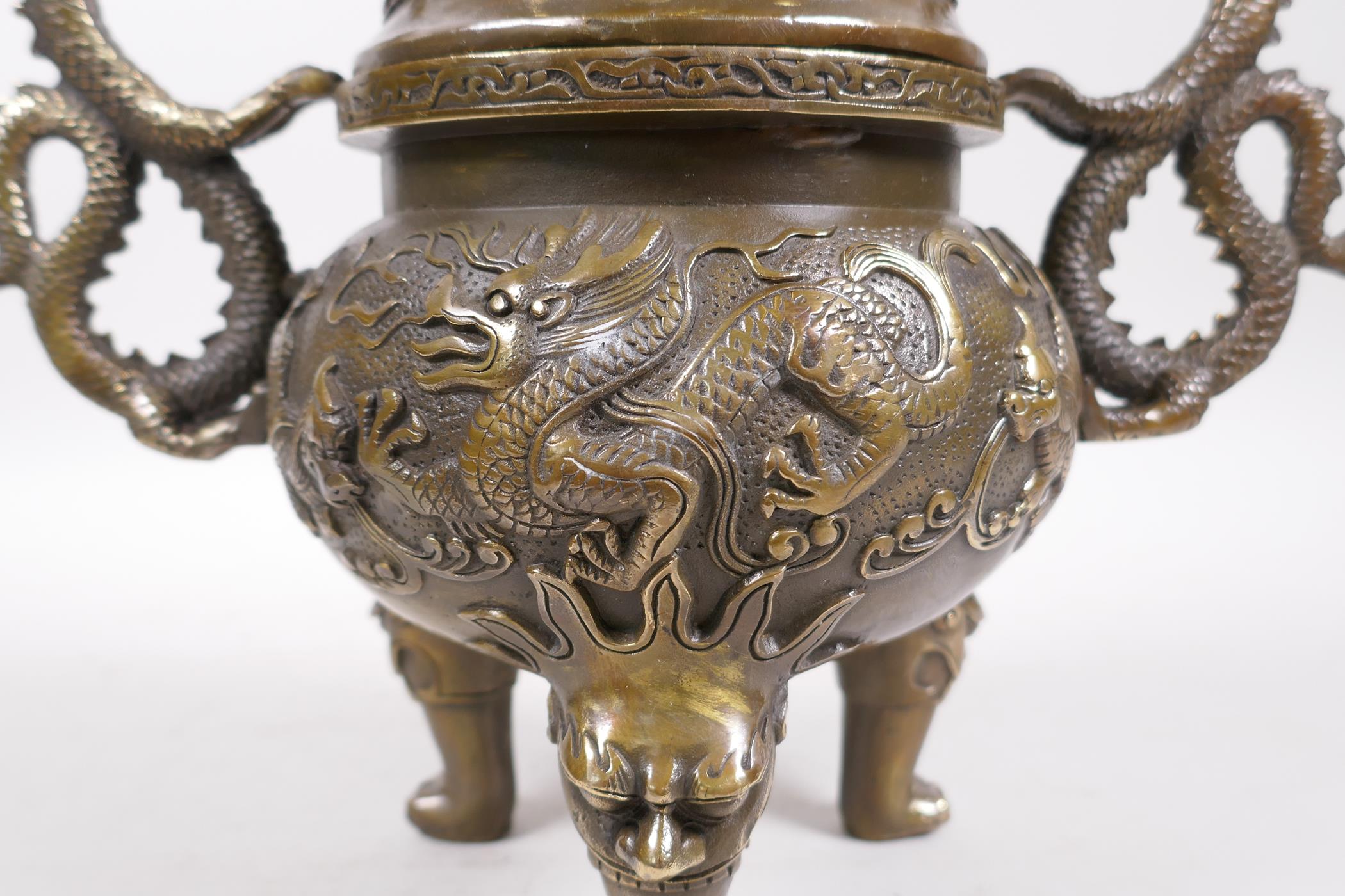 A Bronze Chinese dragon censer and cover with two handles and a fo dog knop, raised on tripod - Image 4 of 6